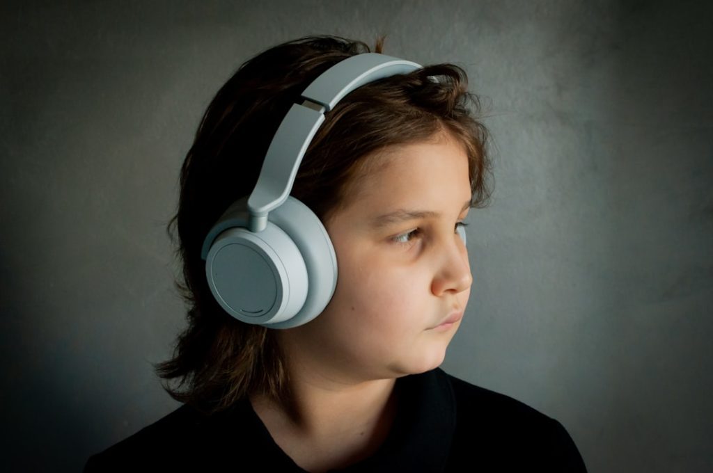 a-child-wears-headphones-while-looking-to-the-side-txahbiansk8